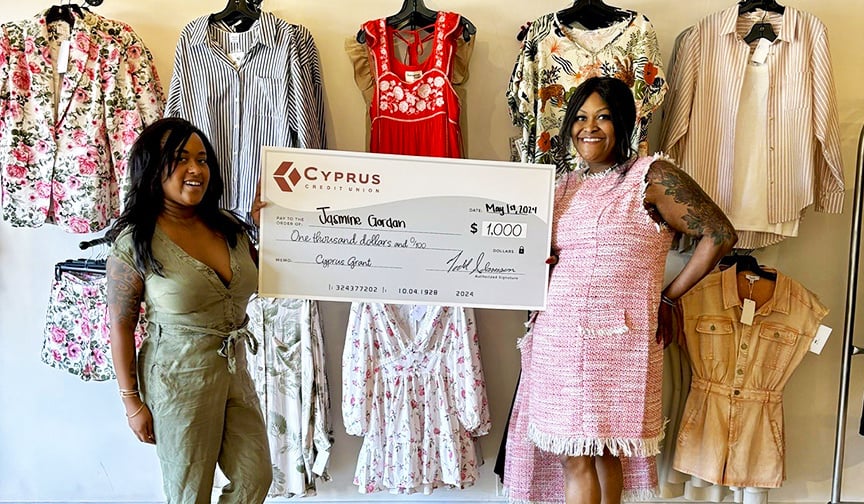 A La Mode owners Jasmine and Angelique Gordon pose with a $1,000 check from Cyprus Credit Union