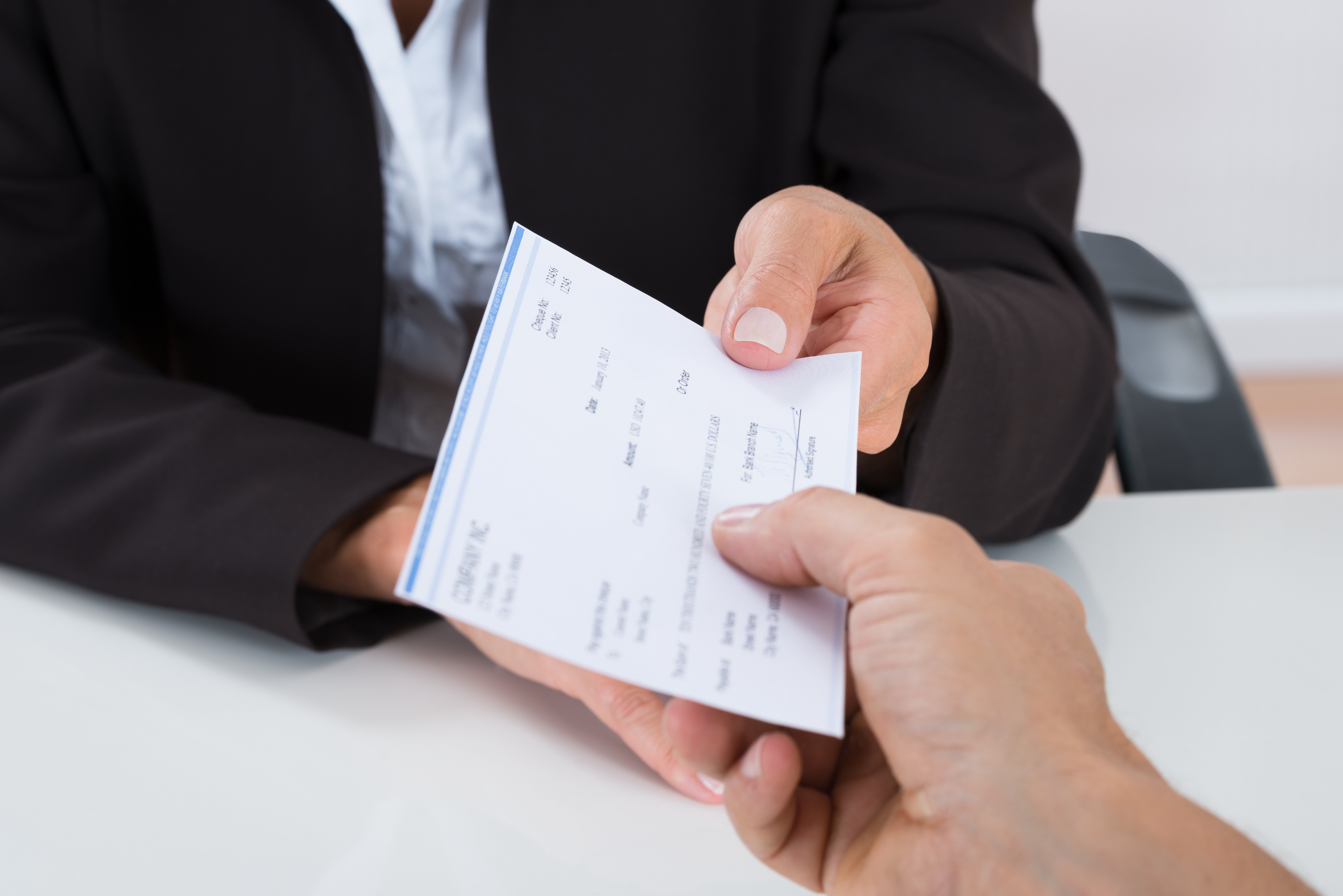 closeup of hands exchanging a check