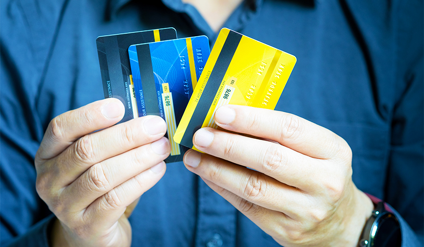 close-up of hands holding three credit cards